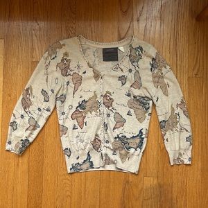 Cardigan with map pattern, hits at mid waist, no missing buttons